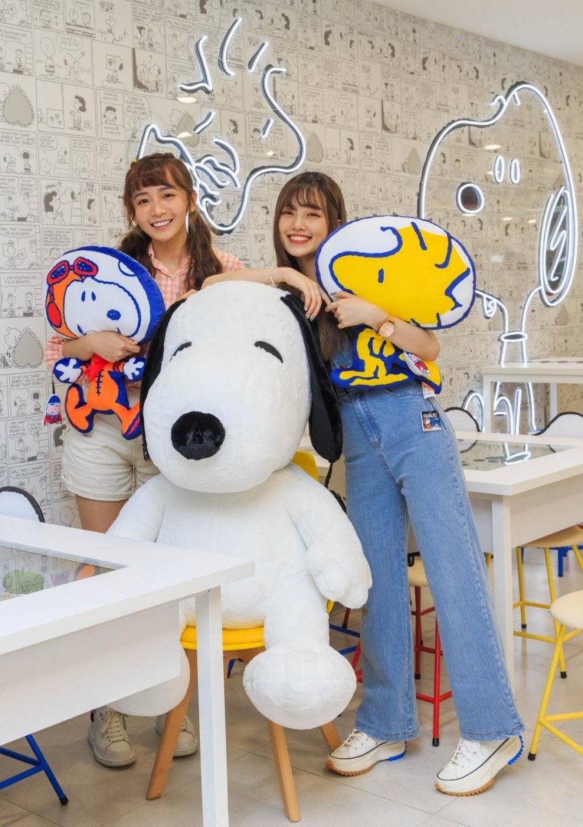 two ladies holding snoopy plushies at Snoopy-themed 7-Eleven Taipei Taiwan
