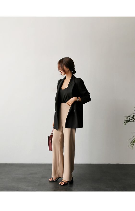 asian woman wearing black blazer and camel trousers