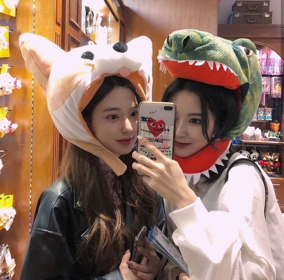 Two girls wearing soft toy hats and taking selfie