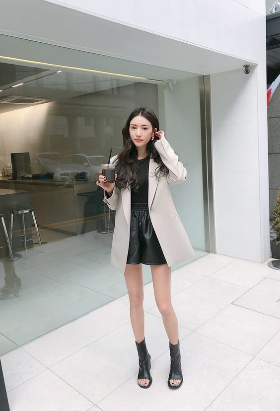 asian woman wearing cream blazer and leather shorts