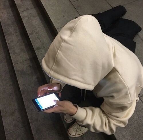 woman wearing hoodie and looking at her phone
