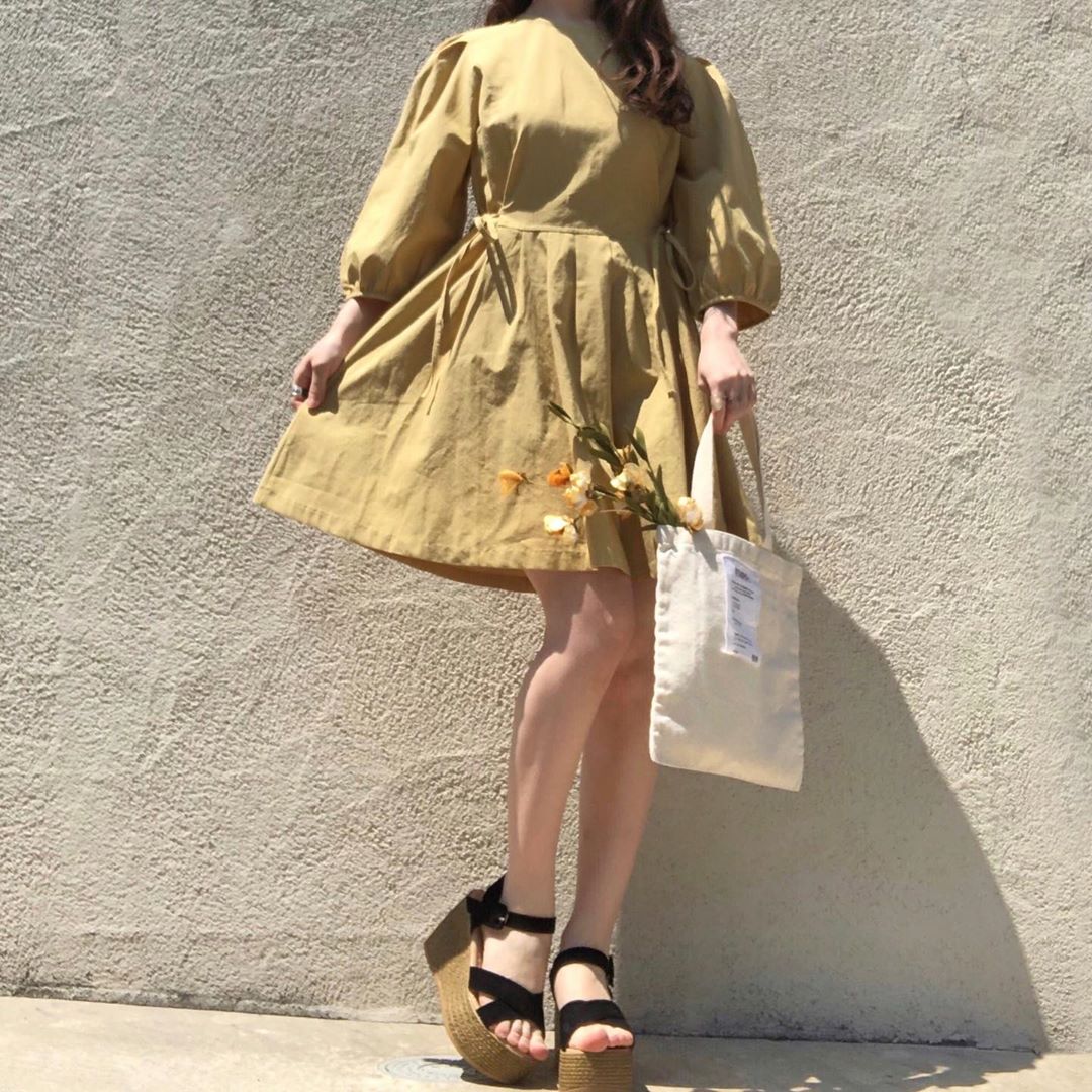 girl wearing yellow mini dress with puff sleeves and wedge heels
