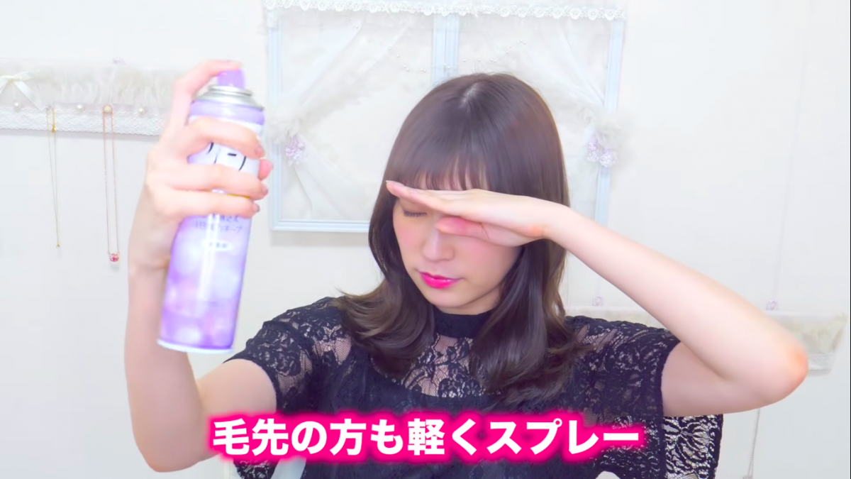 Akari Yoshida applying hairspray and blocking her face
