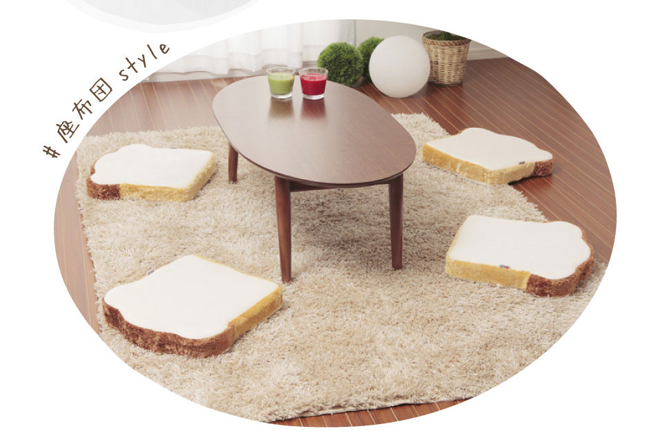 living room with table and four toast bread floor seat cushions