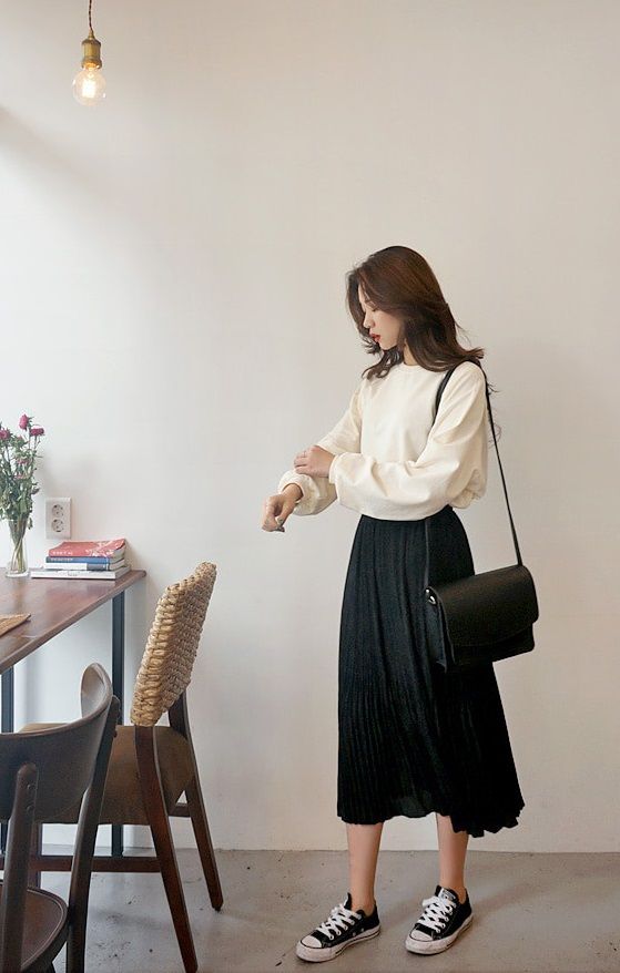 asian woman wearing black midi skirt and white top