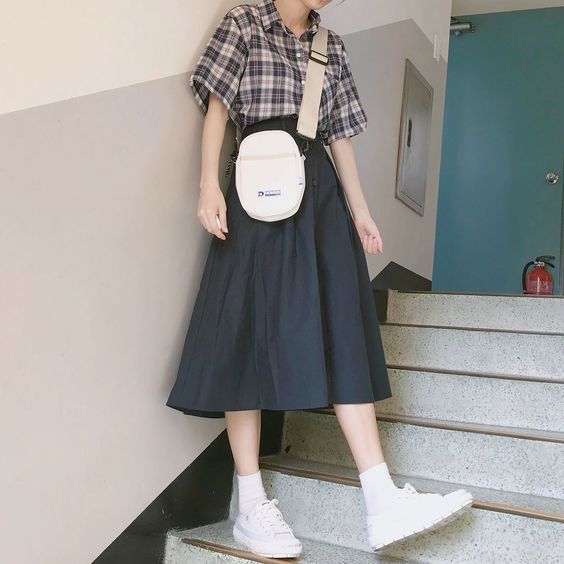 asian woman wearing black midi skirt and checked top