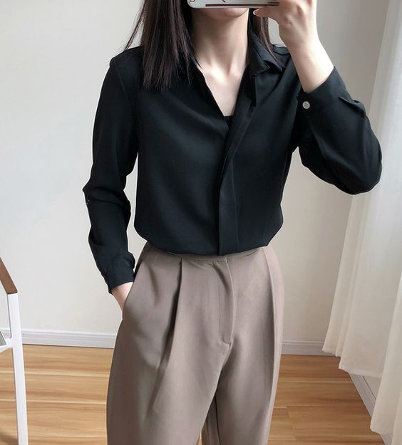 asian woman wearing black collared shirt and brown pants