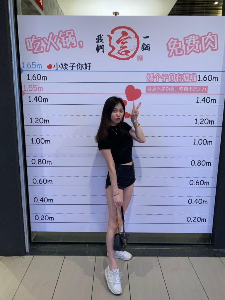 asian woman standing in front of a height chart