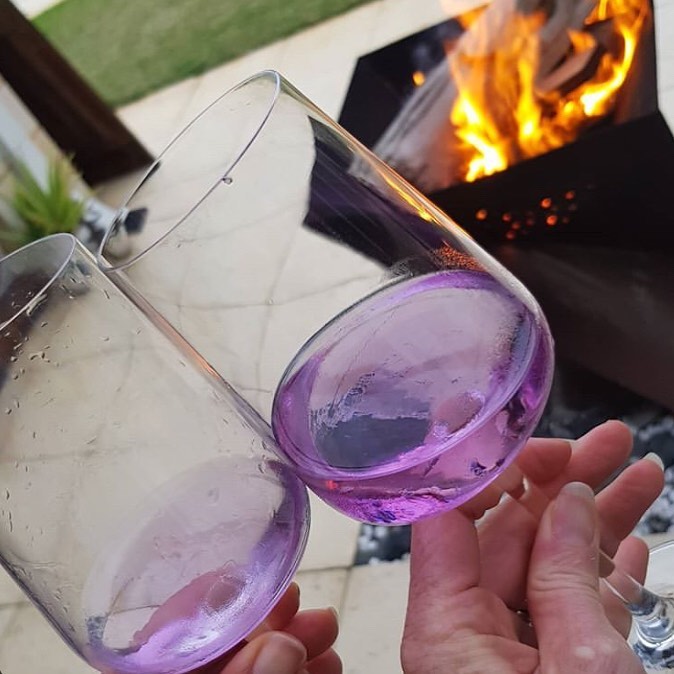 two glasses of purple reign wine clinking together