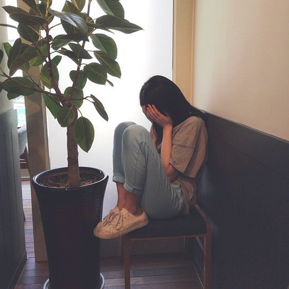 asian girl with face buried in hands