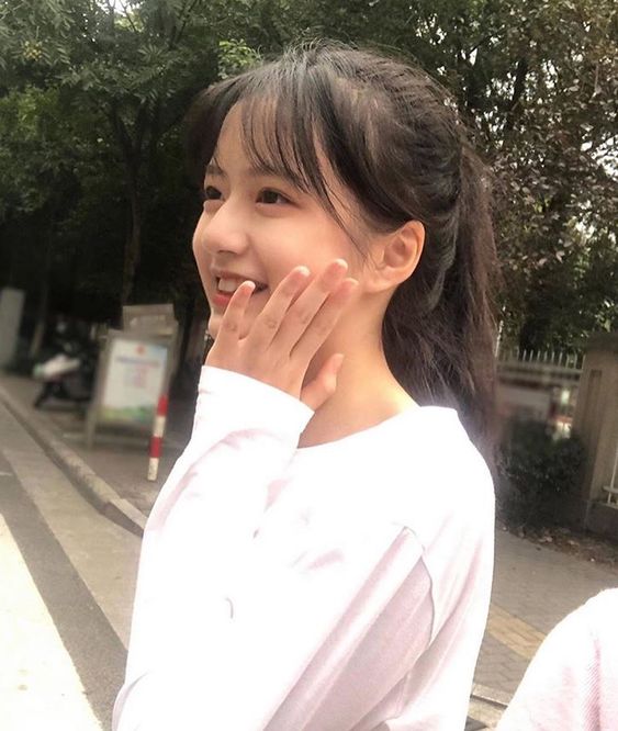 asian girl wearing white top with puffy eyes Shadowed dark under eye circles