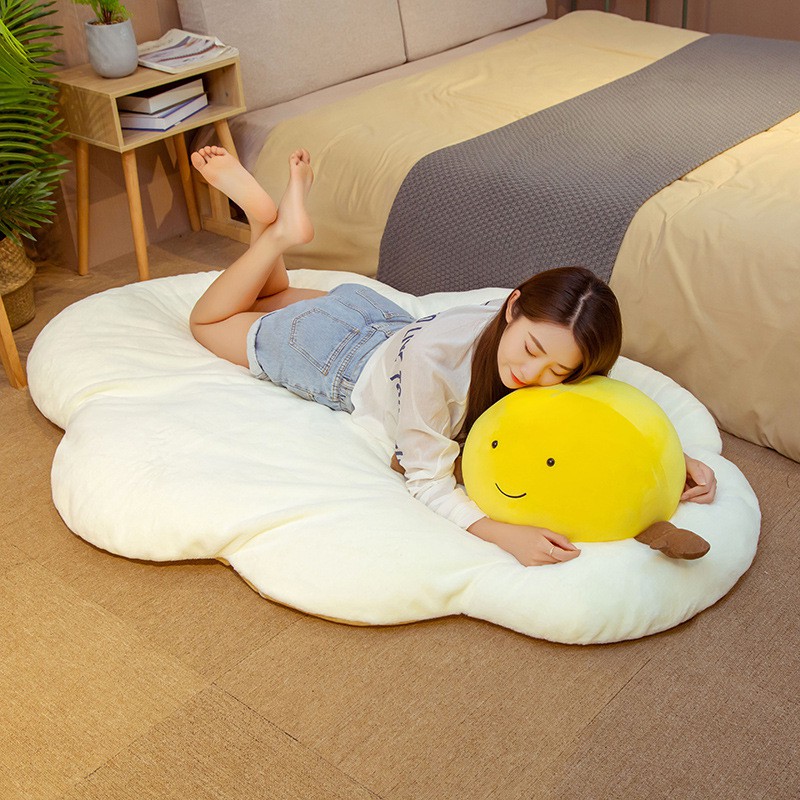 asian girl lying on poached egg floor rug with egg yolk pillow in bedroom