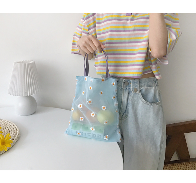 girl holding Mesh floral tote bag in blue with daisies