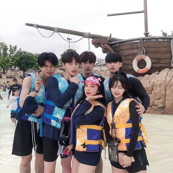 asian friends wearing life jackets at the beach