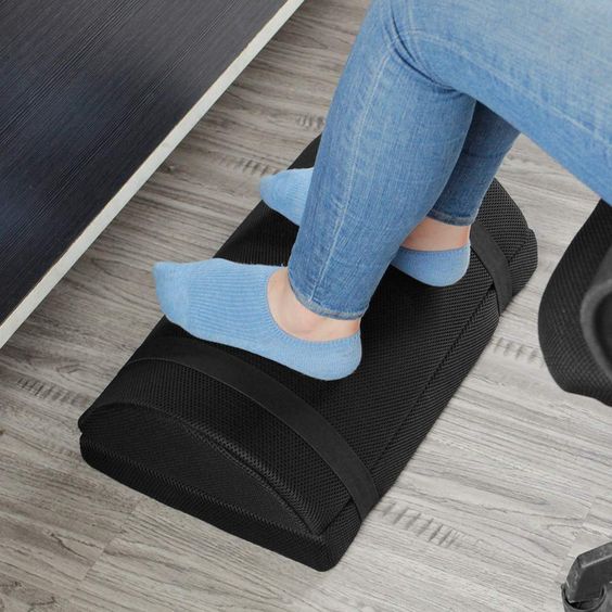 woman wearing jeans and blue socks resting feet on a footstool