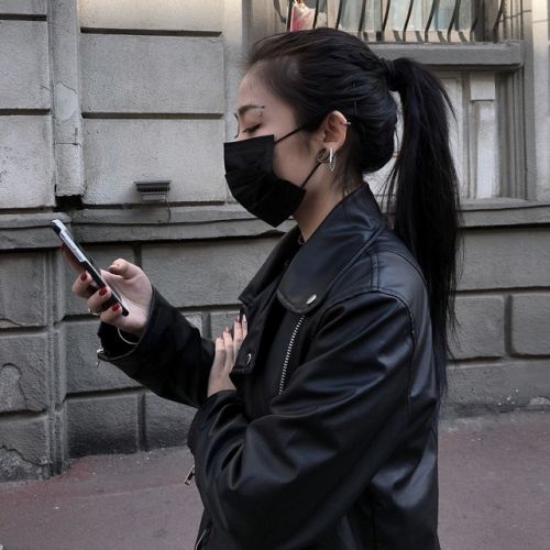 Girl wearing mask and using her phone