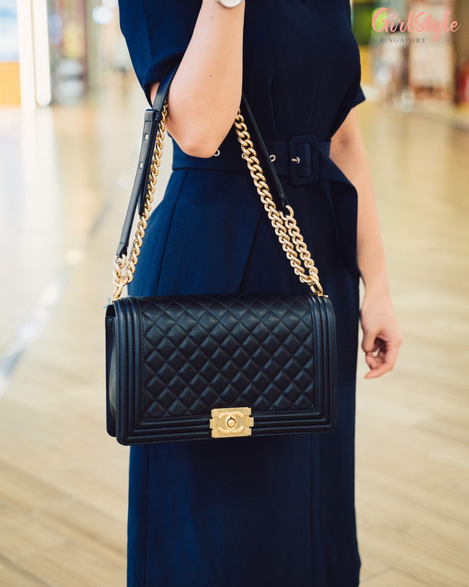 woman carrying black Boy Chanel bag on crook of arm