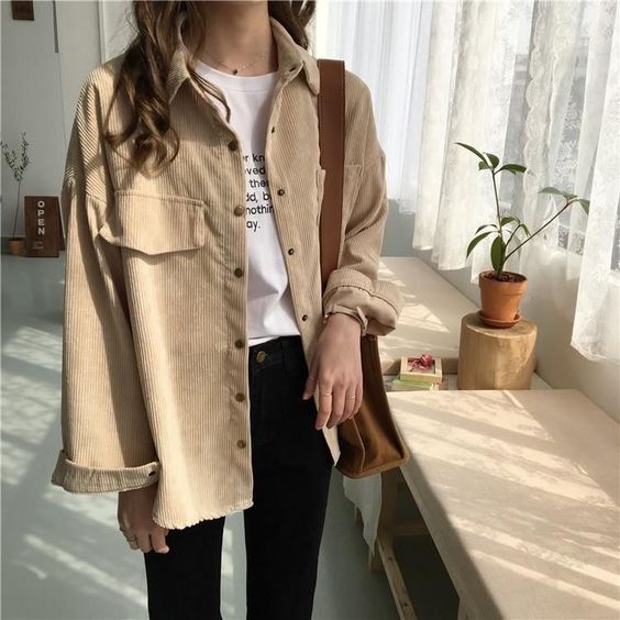 asian girl wearing beige jacket and black jeans at home