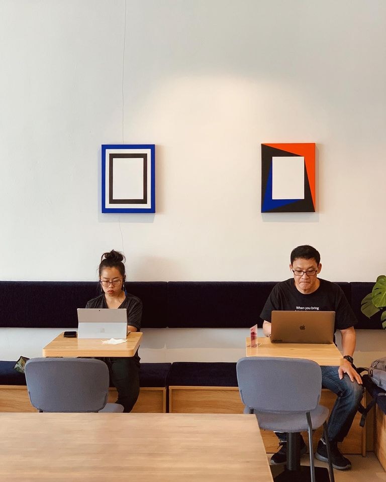 Kong Cafe minimalist interior with colourful artwork on white walls