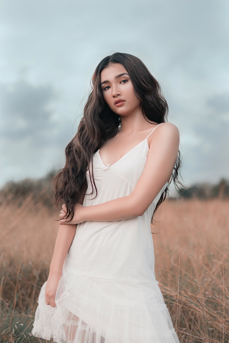 asian girl with long wavy hair wearing a white dress