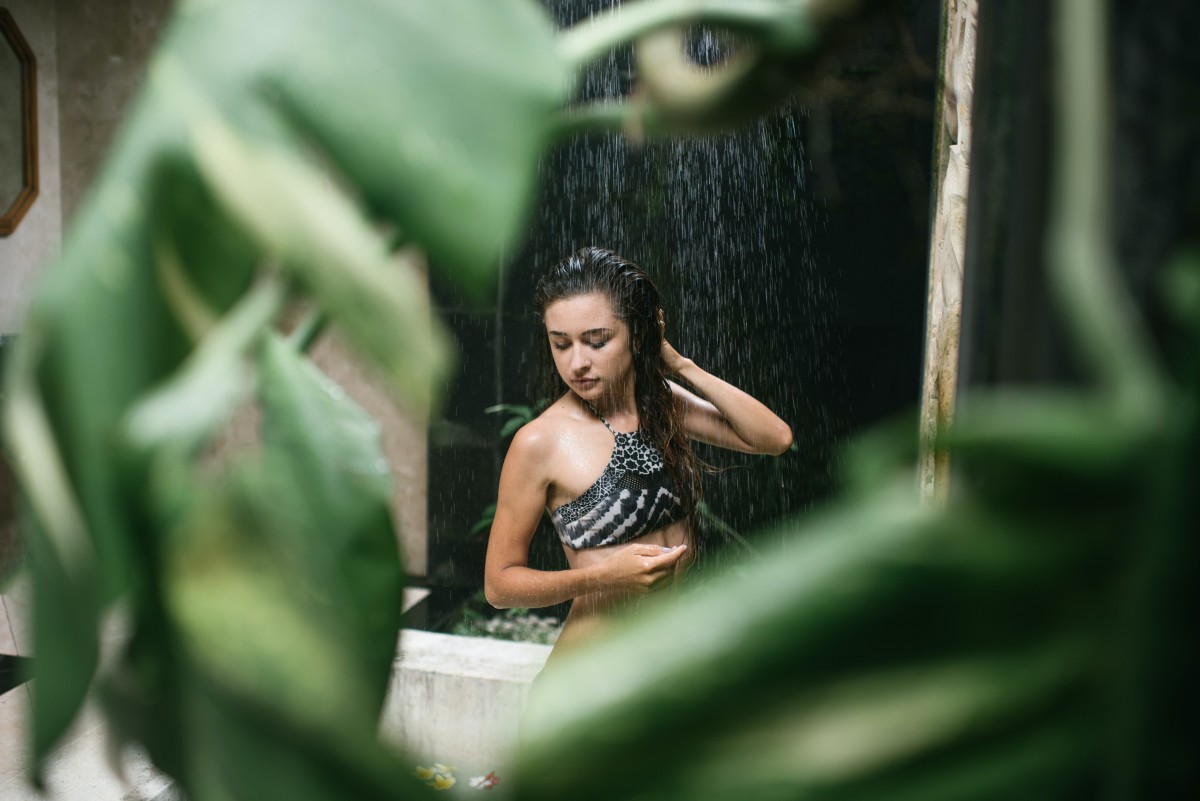 woman washing hair wearing swimsuit