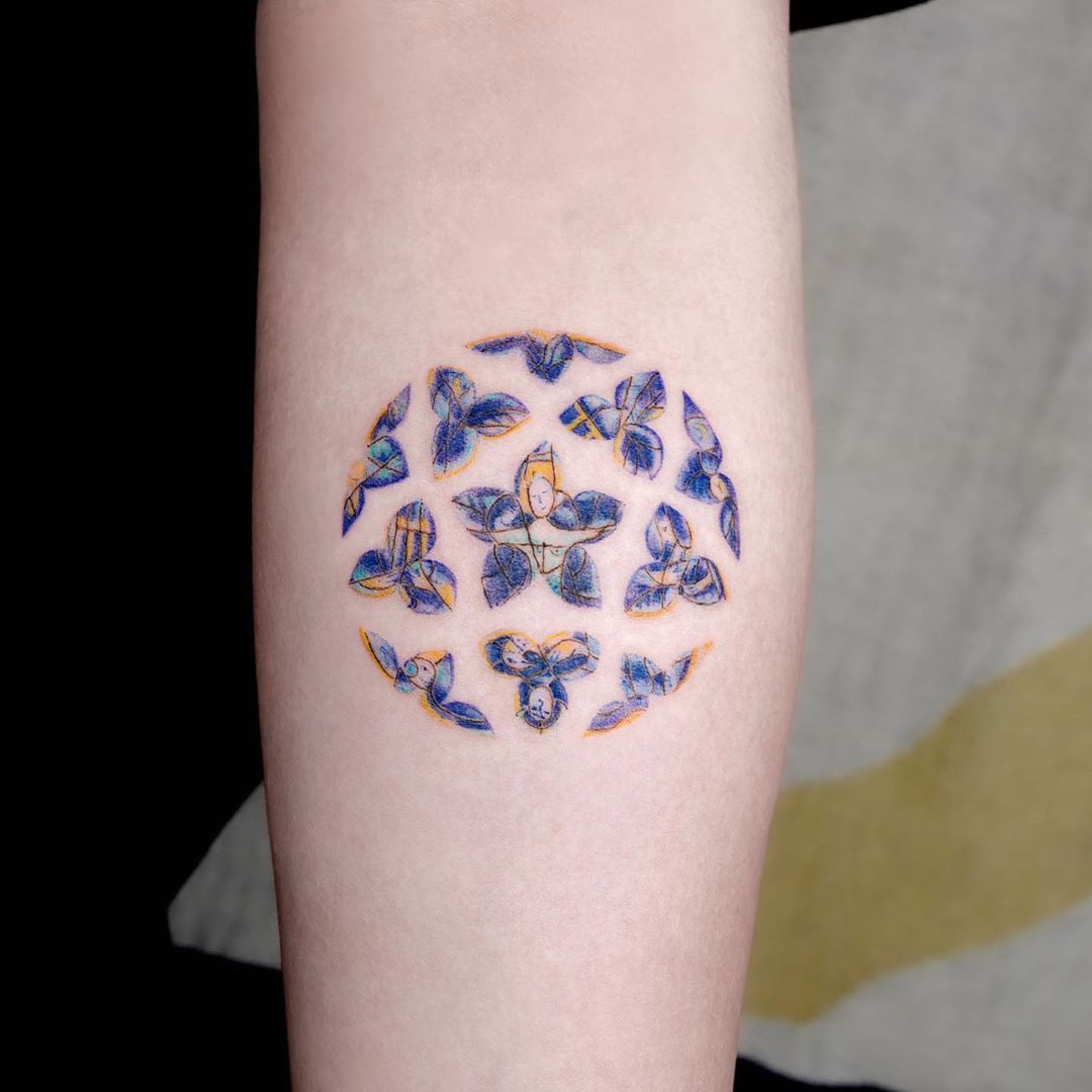 blue and yellow butterflies circle tattoo on arm