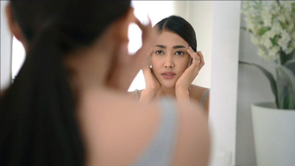 asian girl looking in the mirror