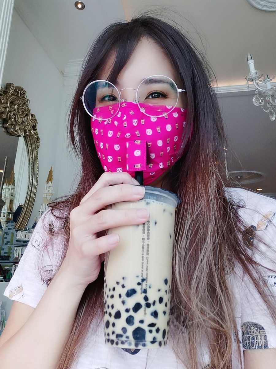 woman wearing foodpanda tiger sugar pink mask and drinking bubble tea