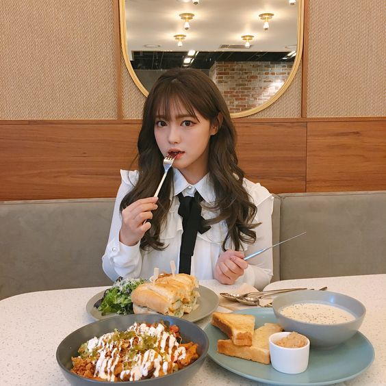 Girl eating salad and sandwiches