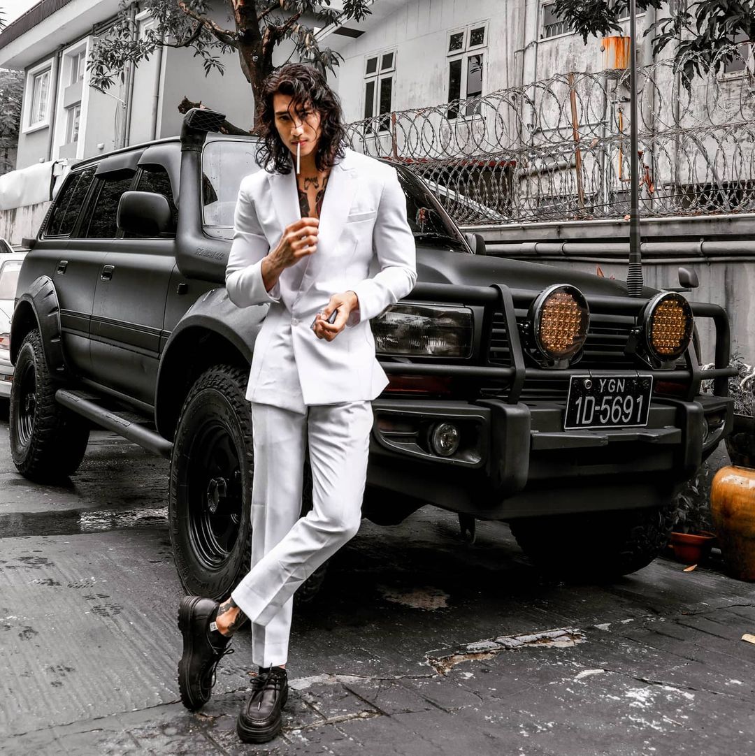 paing takhon wearing white tux in front of car
