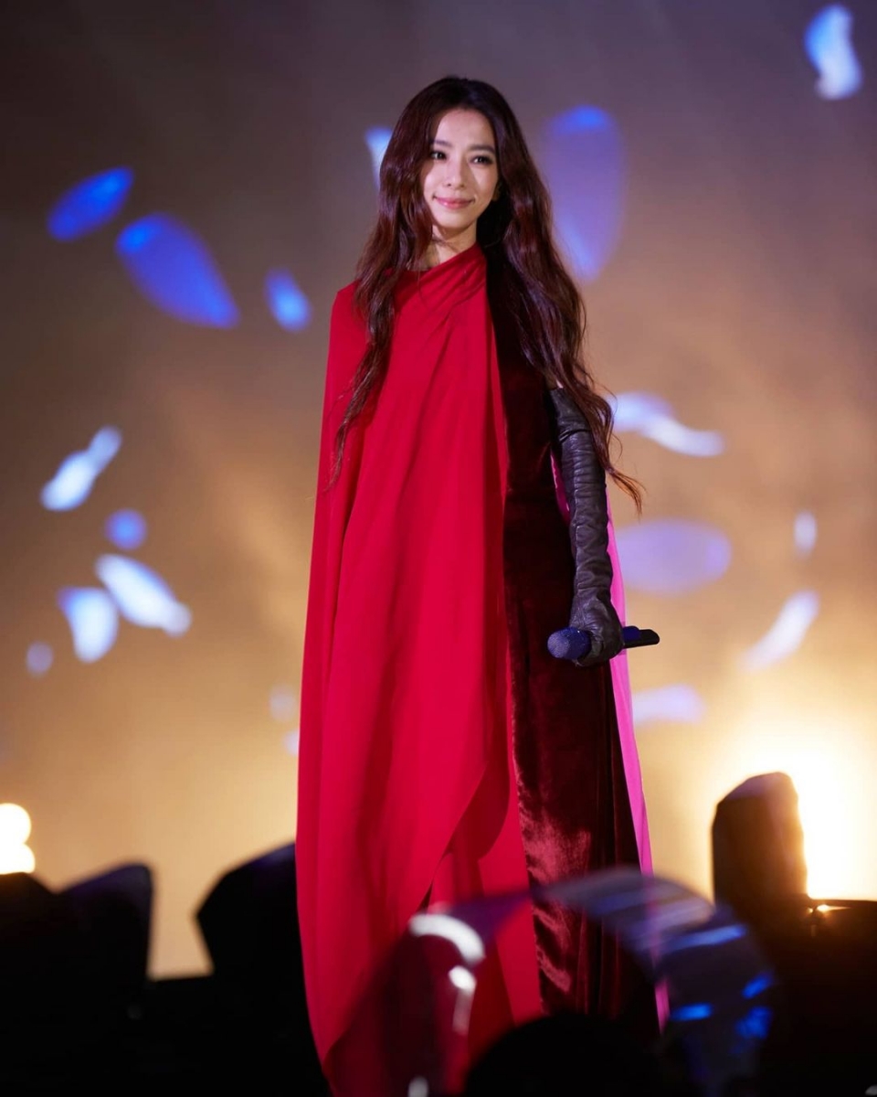 hebe tien performing on stage in a red cape