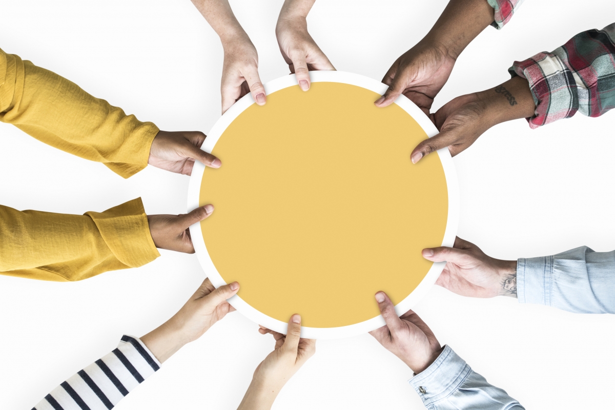 different peoples hands holding yellow circle