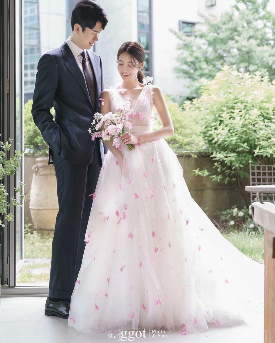 Monique Lhuiller white wedding gown with pink feathers and groom