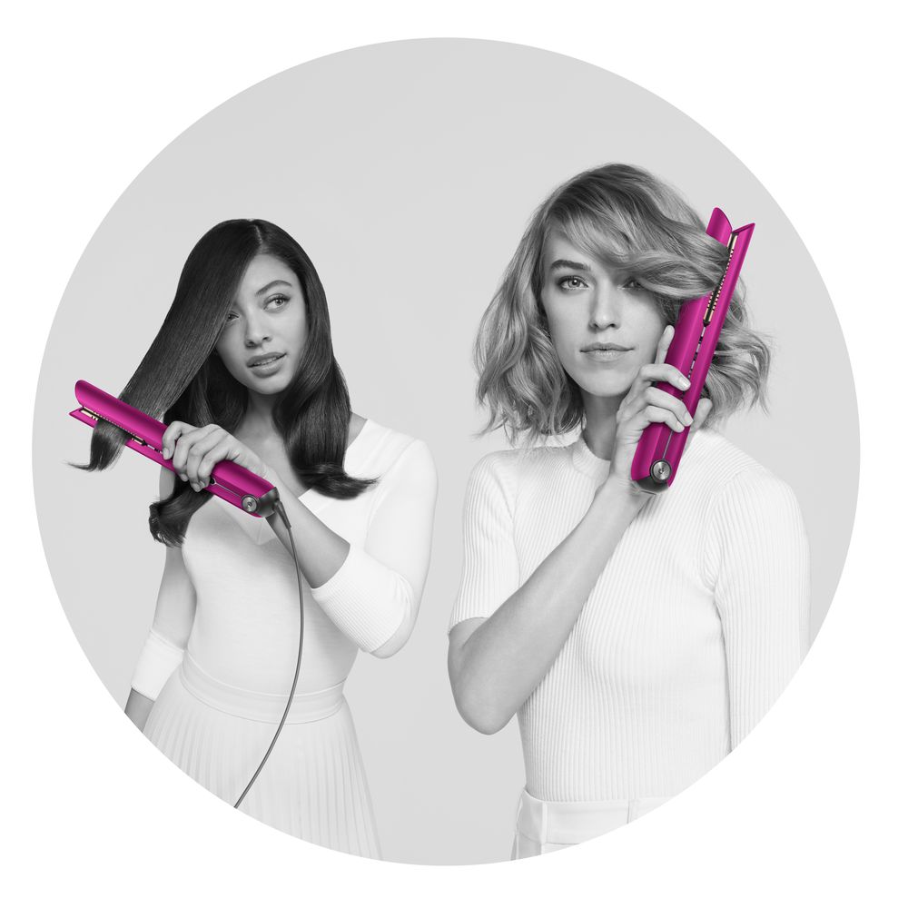 Two ladies styling their hair using the Dyson Corrale in Fushia