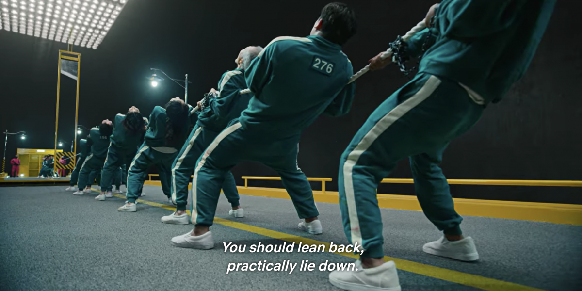 Player 001 telling his team that a good strategy is needed to win a game of tug of war eg, leaning back
