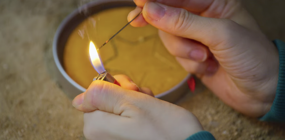 Mi Nyeo using a lighter to heat the needle in Squid Game's Dalgona Candy challenge