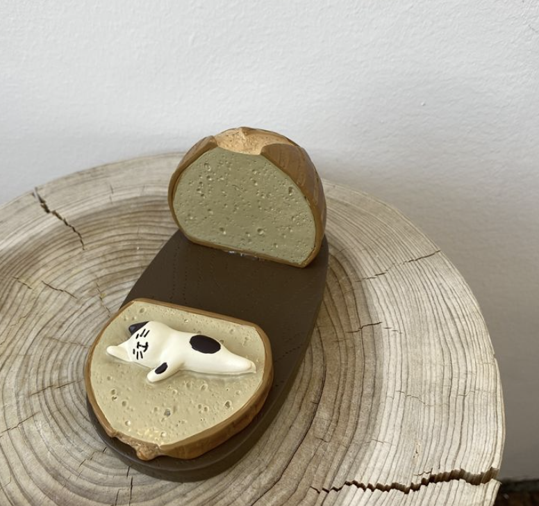 Cat lying on a slice of baguette phone stand
