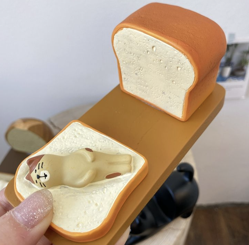 Cat lying on a slice of toast phone stand