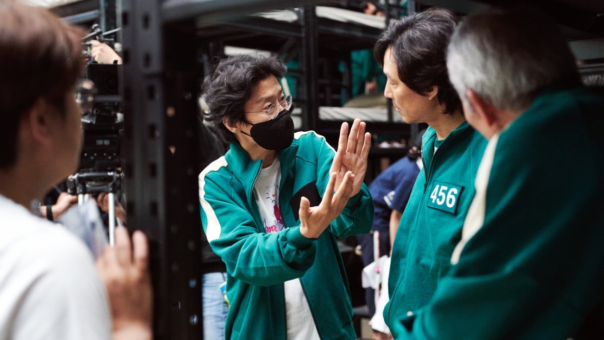 Squid Game's creator, writer and director Hwang Dong-hyuk on set speaking to actor Lee Jung-jae who plays Gi-hun.