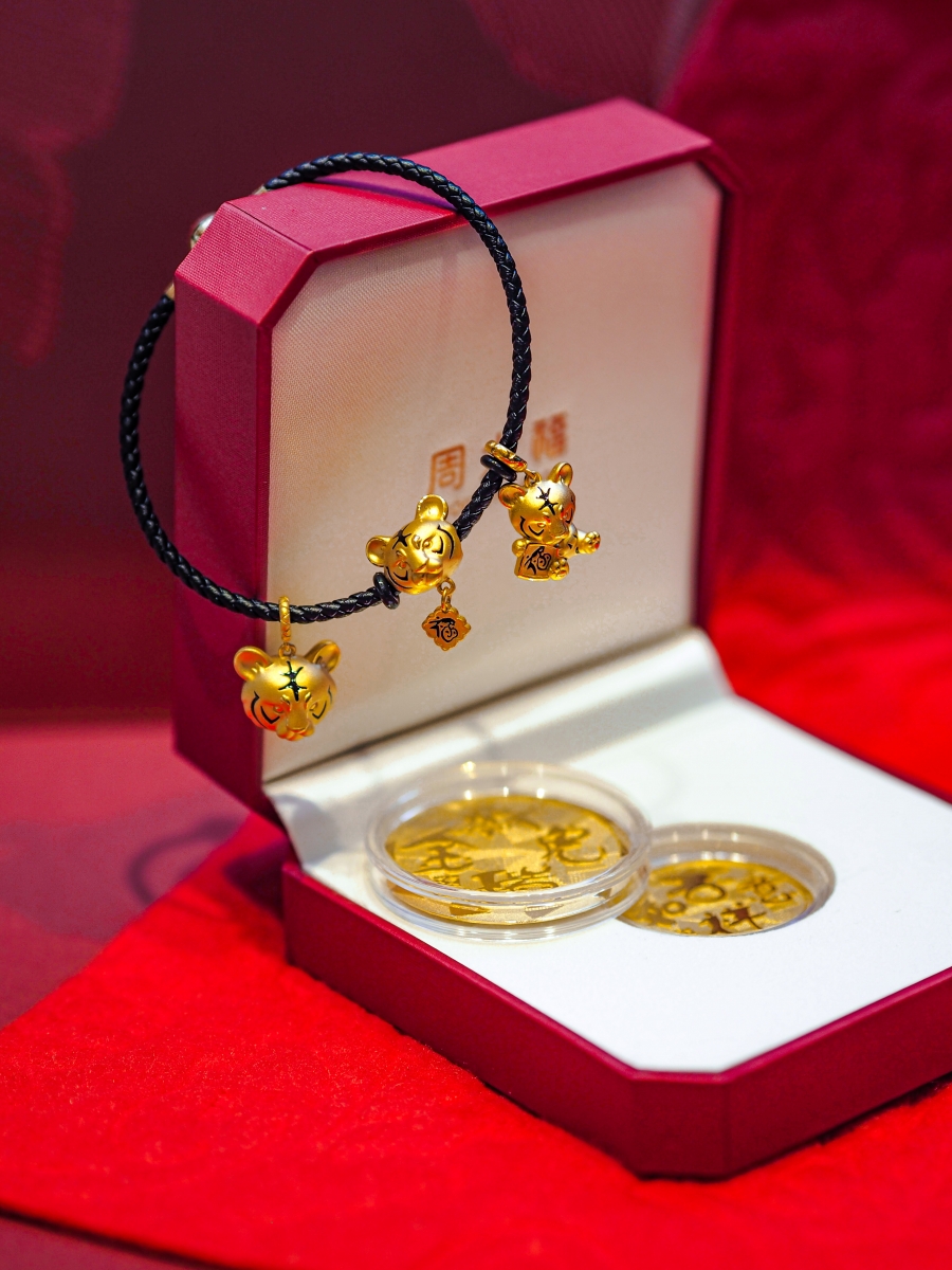 (On bracelet, from left) CHOW TAI FOOK “DrD @ CTF” Pure Gold Pendant, $480, Pure Gold Charm, $470, Pure Gold Pendant, $500. CHOW TAI FOOK 999 Pure Gold Coin - Tiger Zodiac, approx. weight: 20.025g. 