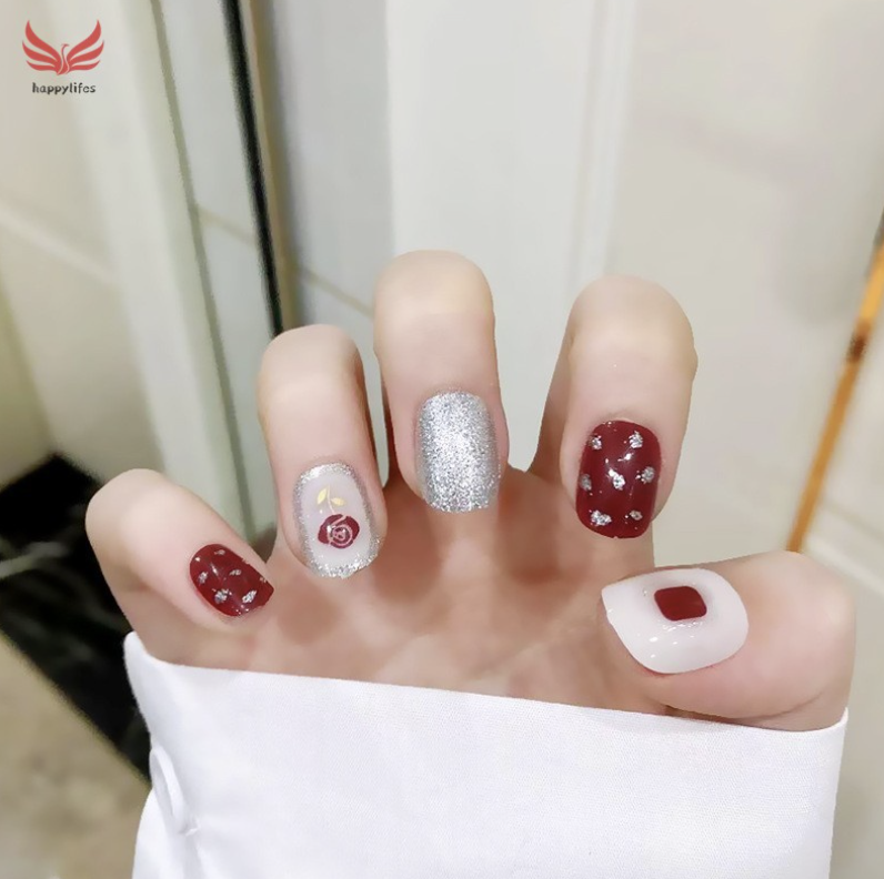 Red nails with a rose design and glitter finishes