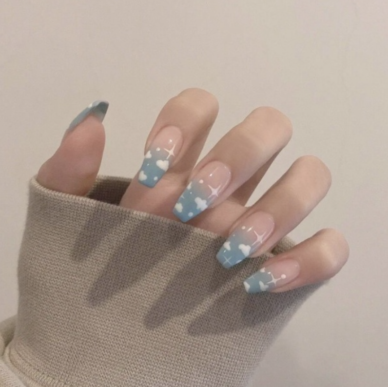 Baby blue gradient nails adorned with clouds