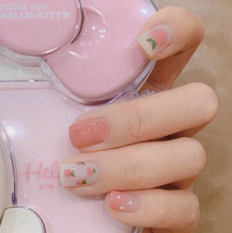 Pale pink nails with peach and polka dot prints
