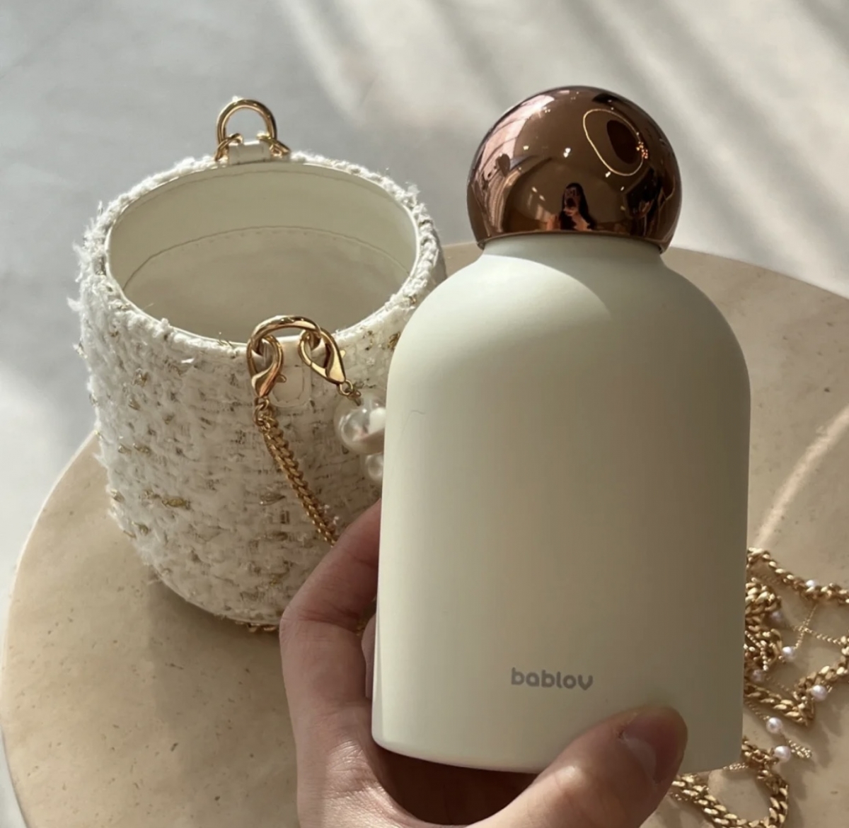 White and gold thermos water bottle with separate tweed cover with chain and pearls