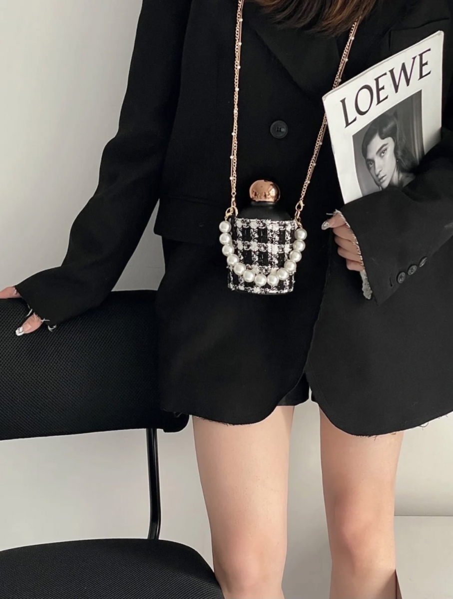 Black thermos water bottle with gold cap in tweed cover with chain and pearls