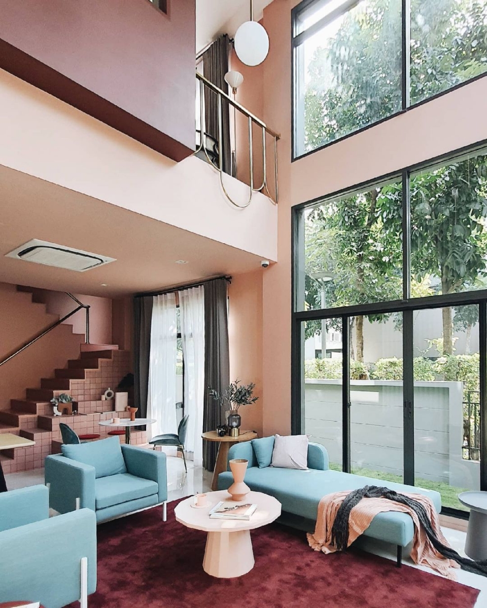 Living room with double height ceiling in an Insta-worthy cafe-themed home in Bangkok, Thailand