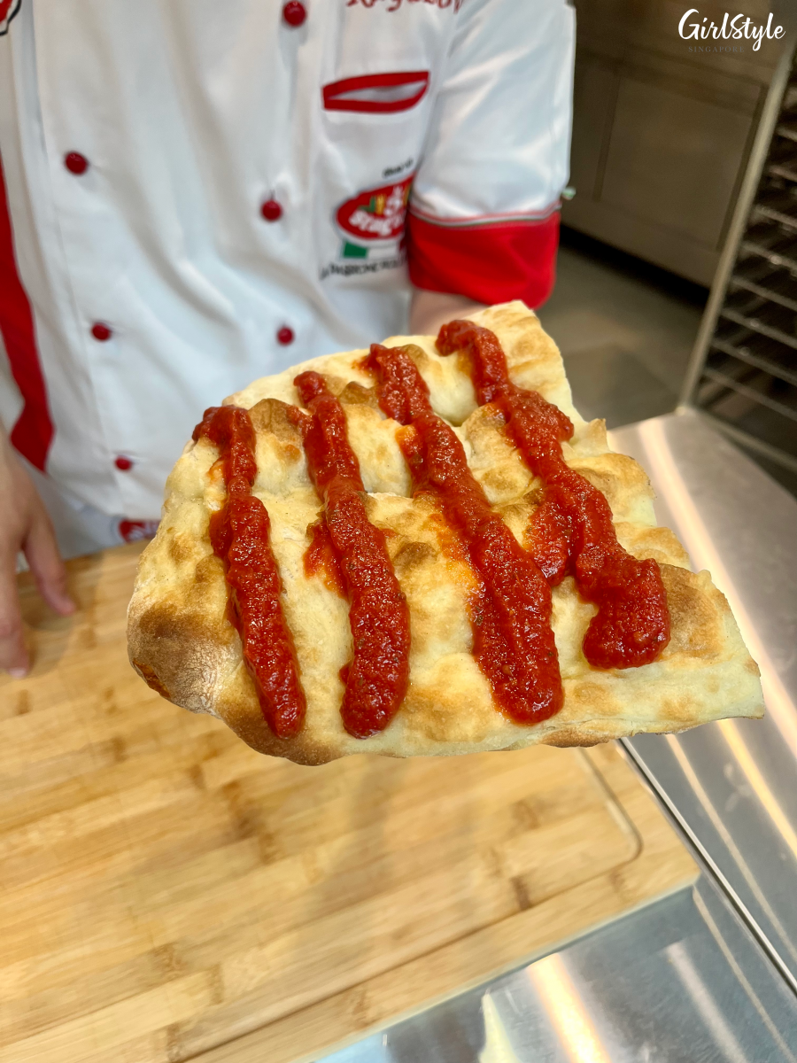 Baked pizza dough with tomato sauce - L’Arte Pizza and Focaccia