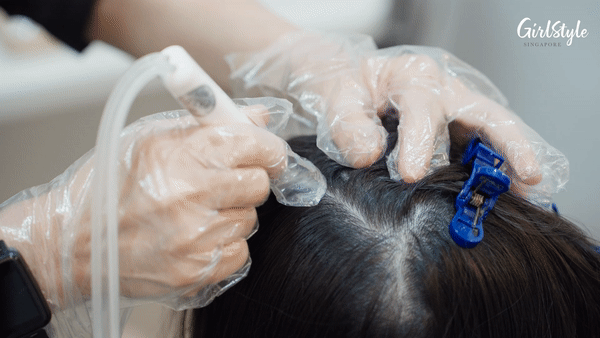 The specialist cleans my scalp with the help of a hydrogen suction machine