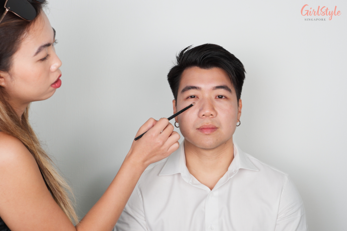 Ying Cui applies ALLIE’s Chrono Beauty Color Tuning UV 02 Sunny Apricot Sunscreen on Nicholas’ under-eye area