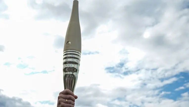 A participant held the Olympic torch during its presentation on the banks of the Seine on 25 July 2023
